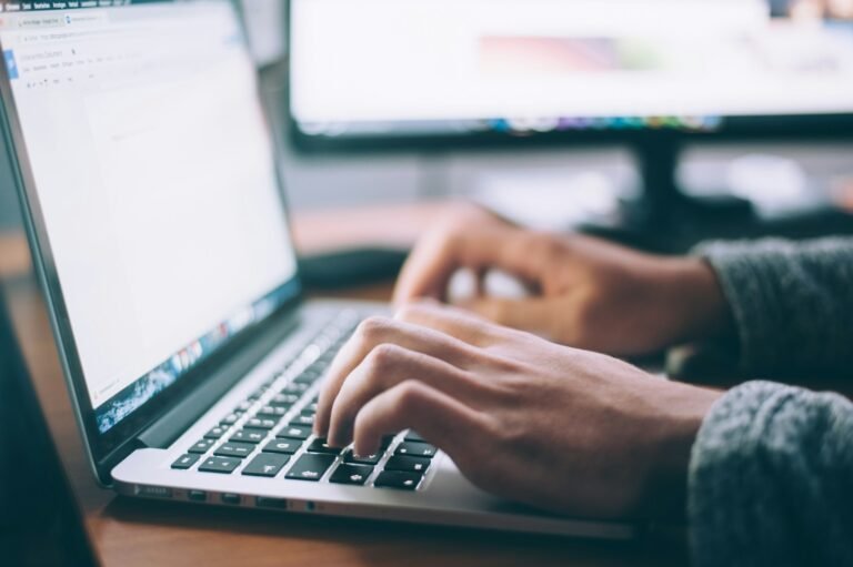 Personne rédigeant un document sur un ordinateur portable