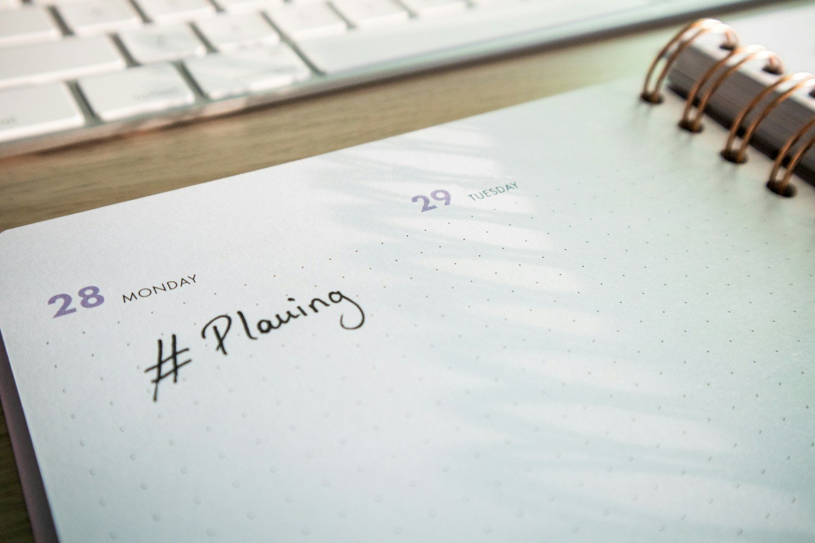 Agenda de planification posé près d’un clavier d’ordinateur