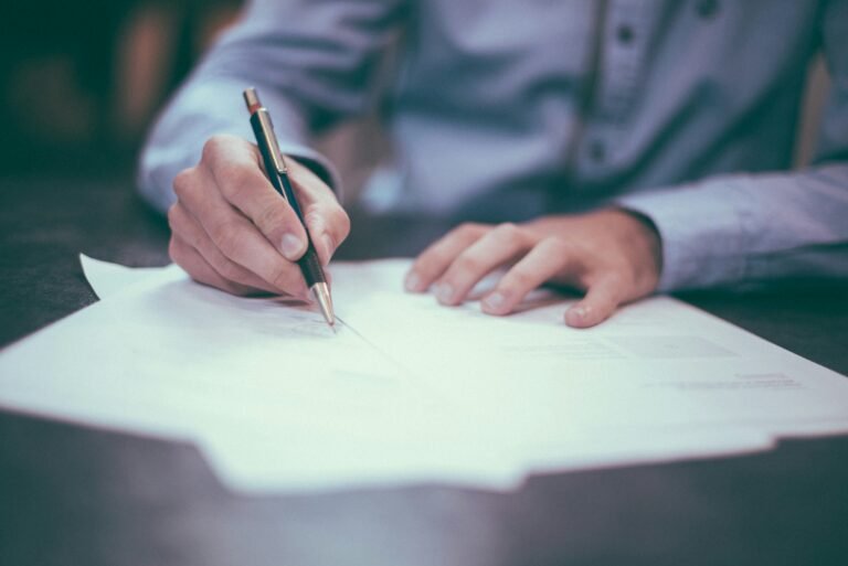 Deux personnes examinent et signent un contrat de travail sur un bureau