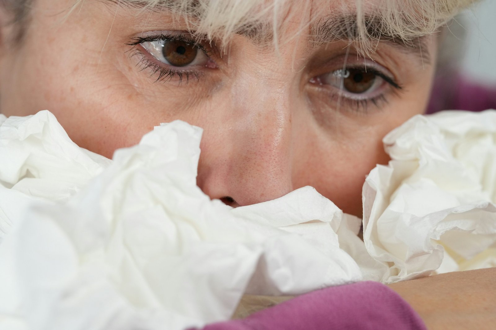 Incapacité de travail en Belgique : personne malade se couvrant le visage avec un mouchoir